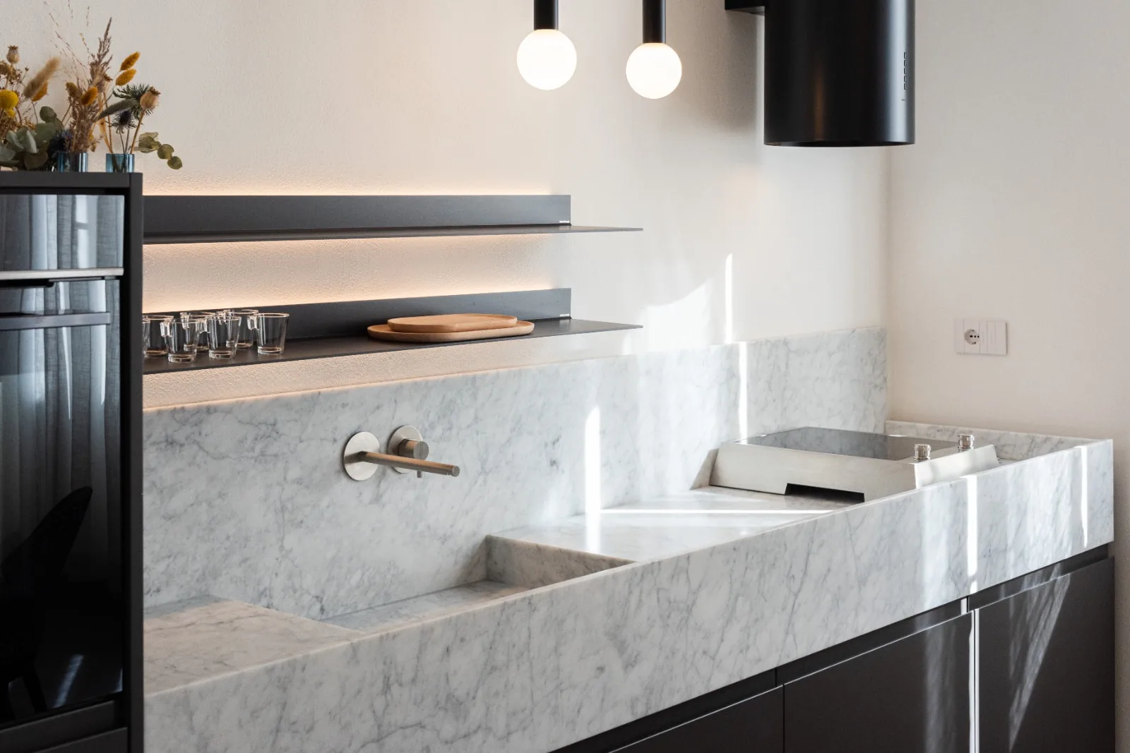 The kitchen in Carrara marble and bronzed steel